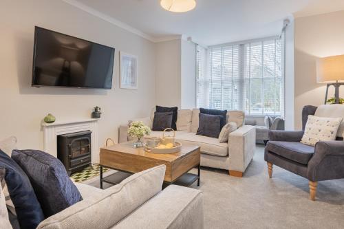 a living room with couches and a tv on the wall at Rockwood- Grasmere family cottage with Hot tub in Grasmere