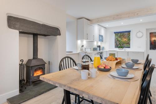 a kitchen and dining room with a table and a wood stove at Rockwood- Grasmere family cottage with Hot tub in Grasmere