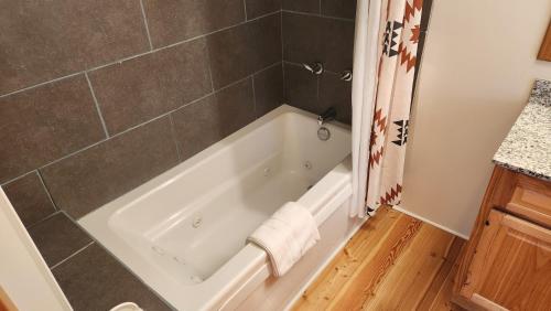a white bath tub in a bathroom with a shower at Beargrass Lodging & RV Resort in Hungry Horse