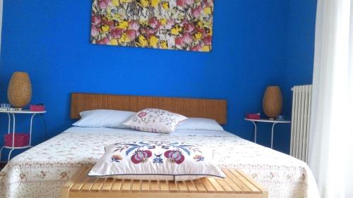 Schlafzimmer mit einem Bett mit blauer Wand in der Unterkunft Camere Due Per Due in Sirolo