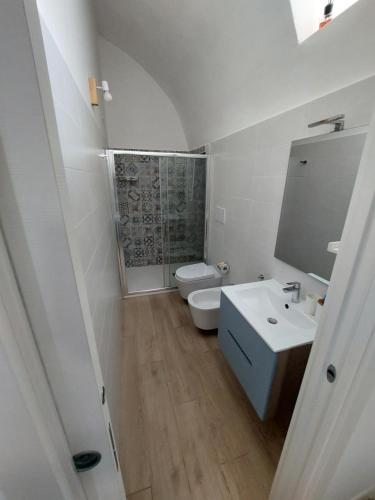 a white bathroom with a toilet and a sink at 1820 Marè in Molfetta