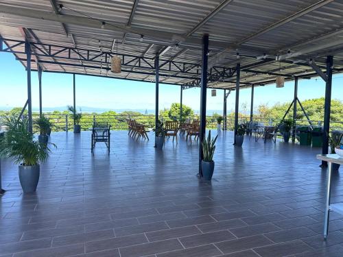 Un patio con mesas y sillas y plantas en macetas. en Hotel Terraza Zoe, en Managua