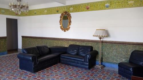 a living room with a couch and a chair at Hotel Marmoy in Cholula