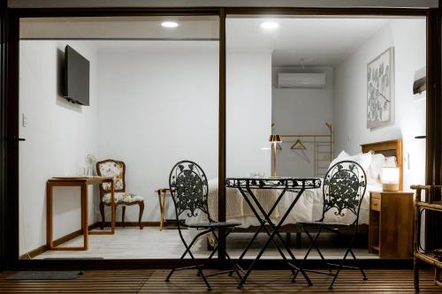 a living room with two chairs and a television at Casa Maqui in Santa Cruz