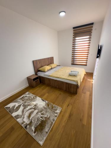 a bedroom with a bed and a wooden floor at I&I Comfort Apartments in Kragujevac