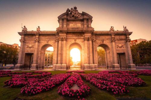 a large building with a bunch of pink flowers at Hostel Las Rosas in Madrid