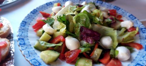 a salad on a blue and white plate on a table at Hotel Hülsmann Garni in Niedersachsen-Stadland