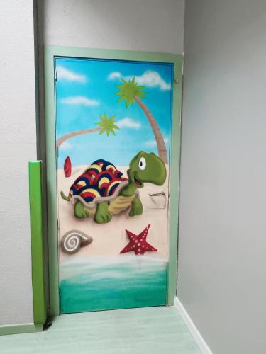 a door with a picture of a dinosaur on the beach at Hostel Las Rosas in Madrid