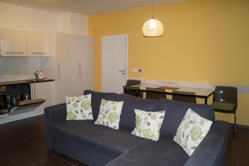 a living room with a blue couch and a kitchen at Apartments Klinovec in Loučná pod Klínovcem