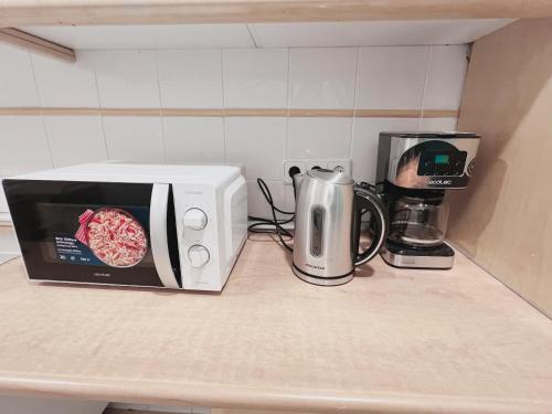 a microwave and a coffee maker on a kitchen counter at Hostel Las Rosas in Madrid