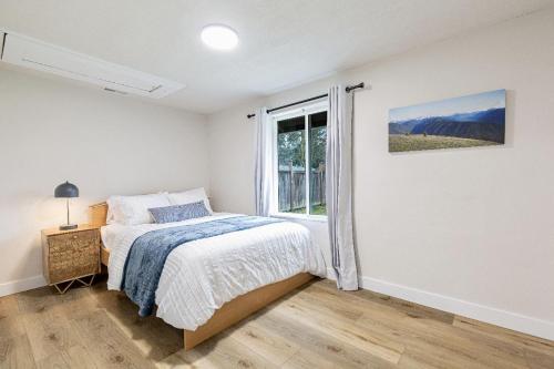 a white bedroom with a bed and a window at Dog Friendly Cozy Remodeled Shoreline Rambler in Shoreline