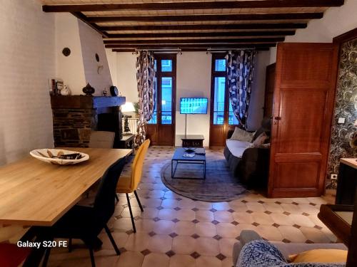 un salon avec une table et un canapé dans l'établissement T3 avec jouissance jardin dans ancien presbytere, à Saint-Mamet