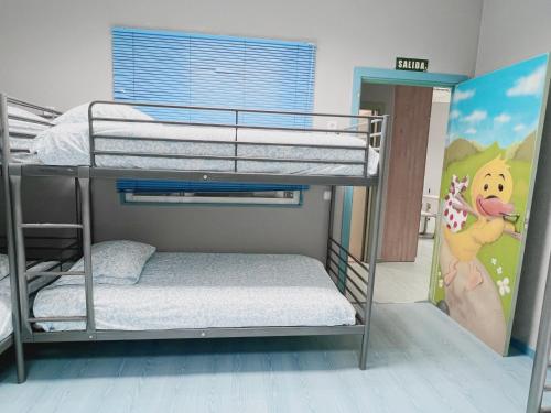sypialnia z łóżkiem piętrowym i malowidłem małpy w obiekcie Hostel Las Rosas w Madrycie
