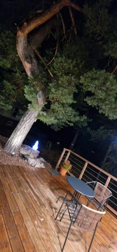 a chair sitting on a deck next to a tree at La Villa du Parc - Alsace & Vosges in Niedermorschwihr