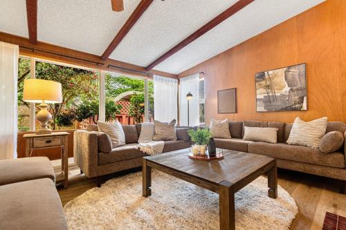 a living room with couches and a coffee table at Spacious Mid Century Modern Sunroom Rambler in Shoreline