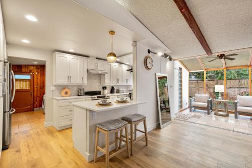 a kitchen with white cabinets and bar stools at Spacious Mid Century Modern Sunroom Rambler in Shoreline