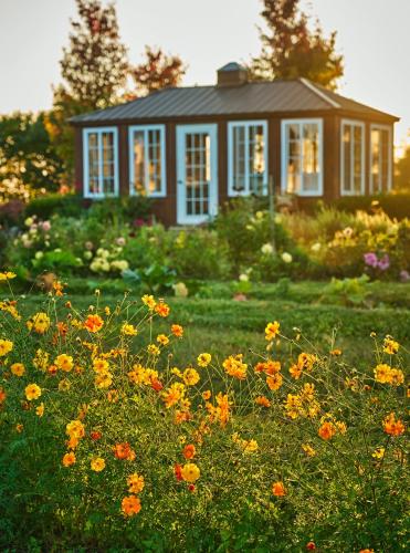 a house with a field of flowers in front of it at Pendry Natirar in Peapack