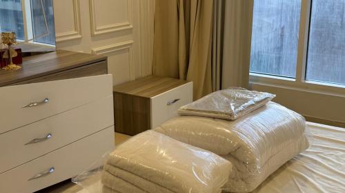 a bedroom with a bed with a pillow and a dresser at Luxury sea view apartment in Dahariz, Salalah شقة بحرية فاخرة بمنطقة الدهاريز السياحية بصلالة ظفار in Salalah