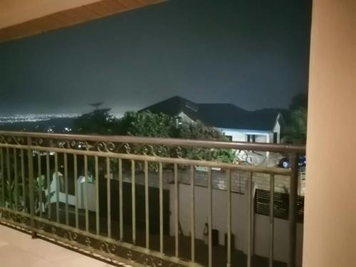 a balcony with a view of the ocean and a house at Diaspora Holiday Villa in Aburi