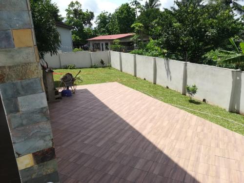a backyard with a wooden deck and a fence at Diaspora Holiday Villa in Aburi