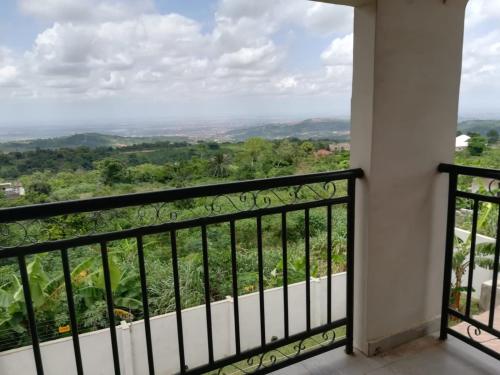 a balcony with a view of the mountains at Diaspora Holiday Villa in Aburi