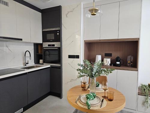 une cuisine avec des armoires blanches et une table en bois dans l'établissement apt cosy proche arena bercy, à Paris