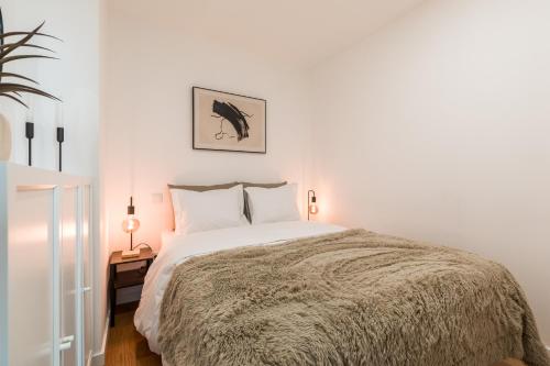 una camera bianca con un grande letto con cuscini bianchi di Douro's Bridge View - Swimming pool a Vila Nova de Gaia