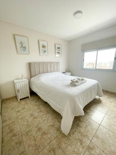 a white bedroom with a large white bed in it at Saavedra 118 8F by depptö in Bahía Blanca
