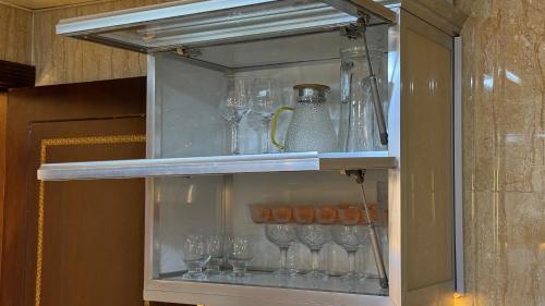 a cabinet filled with wine glasses on a shelf at Luxury sea view apartment in Dahariz, Salalah شقة بحرية فاخرة بمنطقة الدهاريز السياحية بصلالة ظفار in Salalah