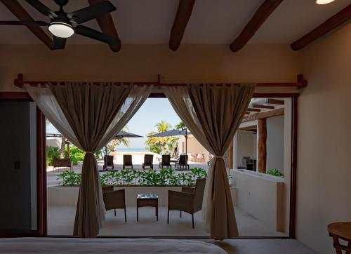 a bedroom with a view of a patio at Beachfront Hotel Boutique DK in Holbox Island