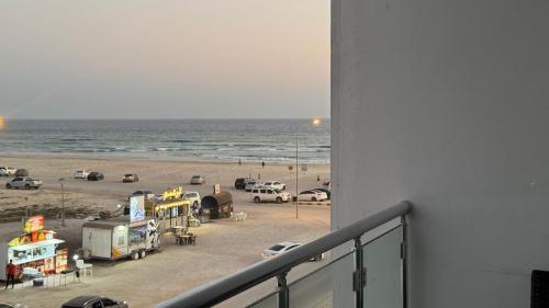 a view of a beach with cars and trucks at Luxury sea view apartment in Dahariz, Salalah شقة بحرية فاخرة بمنطقة الدهاريز السياحية بصلالة ظفار in Salalah