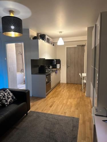 a living room with a black couch and a kitchen at Apartamento Ginebra ch in Geneva