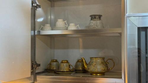 a display cabinet with four pitchers and vases in it at Luxury sea view apartment in Dahariz, Salalah شقة بحرية فاخرة بمنطقة الدهاريز السياحية بصلالة ظفار in Salalah