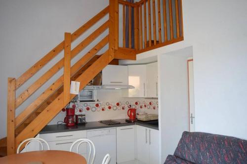 une cuisine avec des placards blancs et un escalier en bois dans l'établissement NP020-042 Maison 3 pièces Mezzanine 2 chambres, Narbonne Plage, à Narbonne-Plage