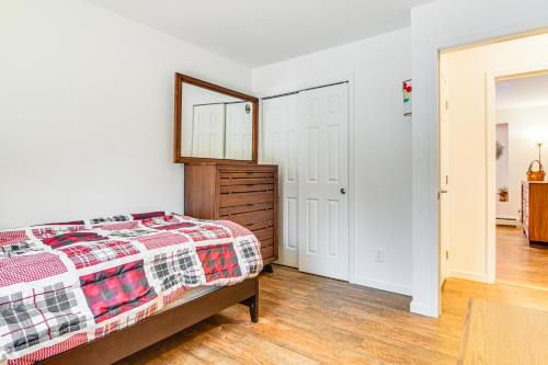 a bedroom with a bed and a mirror at Near Skiing Serene Harrison Retreat with Fire Pit in Bridgton