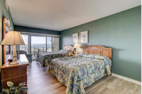 ヒルトン・ヘッド・アイランドにあるBeachside Tennis 1842のベッド2台とバルコニー付きのホテルの部屋