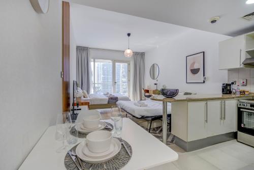 DA86 - Well Design Studio in Dubai Arch tower في دبي: مطبخ وغرفة معيشة مع طاولة مع أطباق عليها