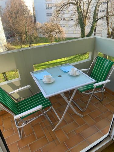 une table et deux chaises sur un balcon dans l'établissement Appartement avec balcon et parking, à Montbéliard