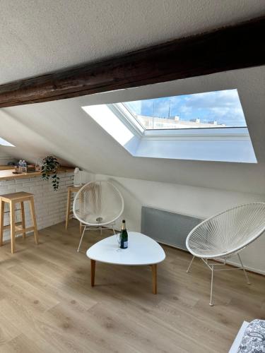 - un salon avec une lucarne, une table et des chaises dans l'établissement Studio Clovis, à Reims