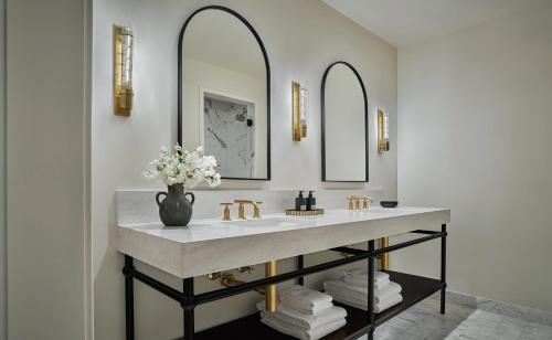 a bathroom with a sink and two mirrors at Pendry Natirar in Peapack