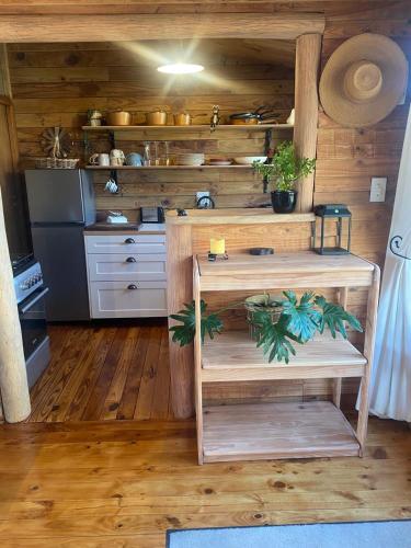 a kitchen with wooden floors and a table with plants at The Country Cabin in Caledon