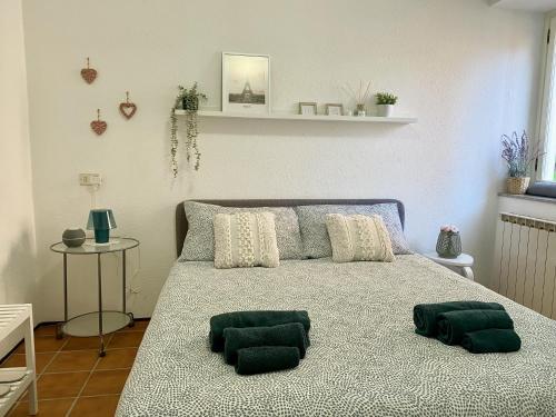 a bedroom with a bed with two green pillows on it at Omegna&Lake - bilocale a un passo dal lago in Omegna