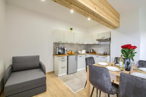 ティリチにあるApartamenty Tylicka Ostojaのテーブルと椅子のあるキッチンとダイニングルーム