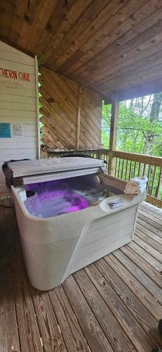 a hot tub sitting on a wooden deck at Southern Oak at Chalet Village - 5 Minutes from Gatlinburg and National Park in Gatlinburg