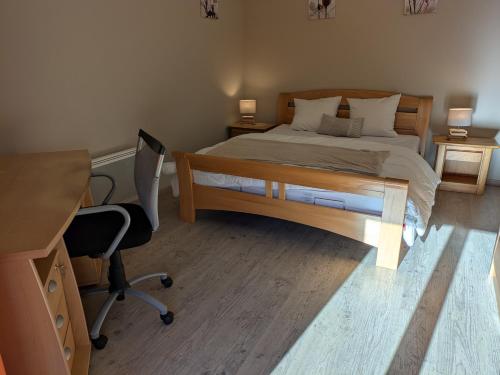 une chambre avec un lit, un bureau et une chaise dans l'établissement Appartement 6 pers, centre-ville- T3, 90m2, à Briançon