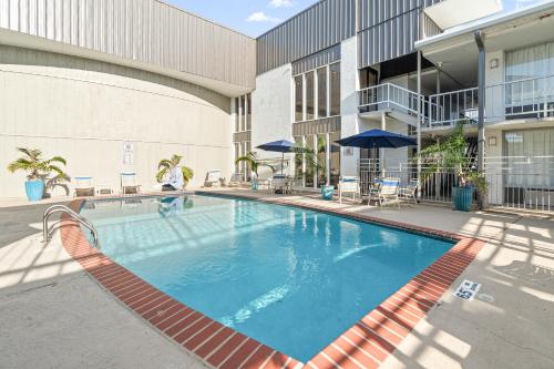a swimming pool in the courtyard of a building at Plantation Inn in Houma