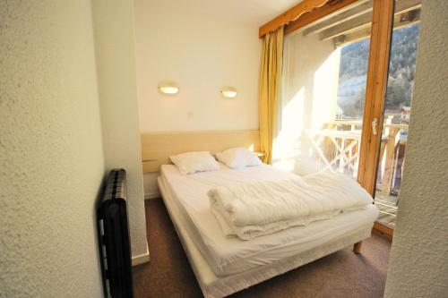 un petit lit dans une chambre avec une fenêtre dans l'établissement Chalets De La Vanoise - CHALETS DE LA VANOISE - CV5205 MAE-4614, à Villarodin-Bourget
