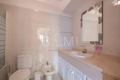 a bathroom with a toilet and a sink and a mirror at Casa do Pico by GALMI in Funchal