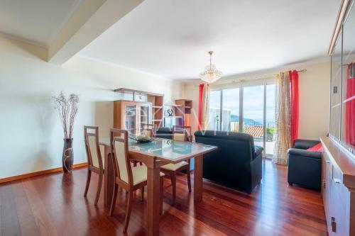 a kitchen and living room with a table and chairs at Casa do Pico by GALMI in Funchal