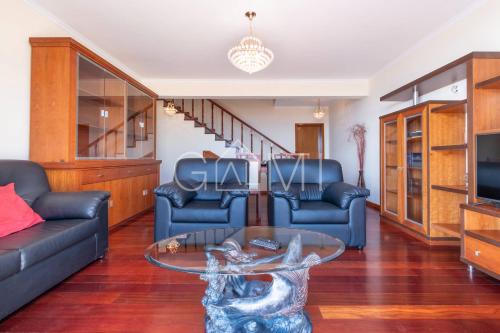 a living room with a couch and a glass table at Casa do Pico by GALMI in Funchal